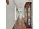 Long hallway with hardwood floors and a curio cabinet at 6008 Sw 103Rd Loop, Ocala, FL 34476