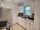 Efficient kitchen with white cabinets and tile flooring at 1777 Oasis Ave, Deltona, FL 32725