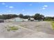 Large paved lot with a small building and cars at 2490 N Woodland Blvd, Deland, FL 32720