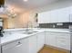 White kitchen boasts double sink, dishwasher, and modern appliances at 4 Oceans West Blvd # 108B, Daytona Beach, FL 32118