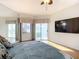 Main bedroom with large TV, ceiling fan, and access to balcony at 4 Oceans West Blvd # 108B, Daytona Beach, FL 32118