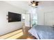 Bedroom with large TV, ceiling fan, and access to bathroom at 4 Oceans West Blvd # 108B, Daytona Beach, FL 32118