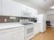 White kitchen with stove, microwave, and refrigerator at 4 Oceans West Blvd # 108B, Daytona Beach, FL 32118