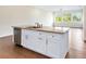 Modern kitchen island with granite countertop and white cabinets at 425 Sandy Bluff Trl, Deland, FL 32724
