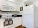 White appliances and cabinets in this galley-style kitchen at 600 N Boundary Ave # 106D, Deland, FL 32720