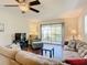 Living room with sectional sofa, hardwood floors, and access to balcony at 600 N Boundary Ave # 106D, Deland, FL 32720