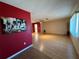 Open living room with wood-look floors and red accent wall at 1008 Wilmington Dr, Deltona, FL 32725