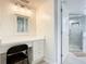 White vanity with a mirror and a chair in a bright bathroom at 3333 S Atlantic Ave # 605, Daytona Beach Shores, FL 32118