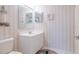 Small bathroom with white vanity and striped wallpaper at 4 Oceans West Blvd # 301C, Daytona Beach Shores, FL 32118