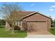 Single-story home with a brown exterior, two-car garage, and well-manicured lawn at 4747 Nw 35Th Lane Rd, Ocala, FL 34482