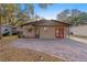 Tan single story home with brick paver driveway and landscaped yard at 6 Rosalie Oaks Blvd, Lake Wales, FL 33898