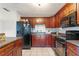 Kitchen with dark wood cabinets, black appliances, and an island at 6 Rosalie Oaks Blvd, Lake Wales, FL 33898