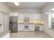 White kitchen with granite countertops and stainless steel appliances at 6180 Knotty Pine Ct, Port Orange, FL 32127