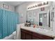 Bathroom with teal shower curtain, wood vanity, and updated fixtures at 101 Marathon Ln, Sanford, FL 32771