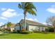 Green house with palm trees, manicured lawn, and attractive landscaping at 101 Marathon Ln, Sanford, FL 32771
