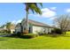 Side view of a green house showcasing landscaping and palm trees at 101 Marathon Ln, Sanford, FL 32771