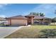 Brick home with a two-car garage and well-maintained lawn at 1185 N Old Mill Dr, Deltona, FL 32725
