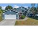 Curb appeal abounds at this charming teal home with a 2-car garage at 3113 Birds Rest Pl, Kissimmee, FL 34743