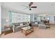 Bright living room with large windows, comfortable seating and a ceiling fan at 3311 S Atlantic Ave # 304, Daytona Beach Shores, FL 32118