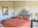Bright bedroom with coral bedding and a decorative mirror at 5300 S Atlantic Ave # 19-502, New Smyrna Beach, FL 32169