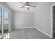 Bedroom with wood-look floors, ceiling fan, and sliding glass doors to a balcony at 1661 Bismarck Dr, Deltona, FL 32725