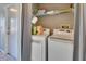 Well-lit laundry room with washer, dryer, and storage shelves at 2585 Delbarton Ave, Deltona, FL 32725