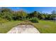 Large backyard with grassy areas and a paved patio. Some overgrown vegetation is present at 4851 Orange Ave, Port Orange, FL 32127