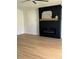 Living room with black shiplap fireplace, wood mantel, and light wood-look floors at 7810 Country Chase Ave, Lakeland, FL 33810