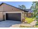 Updated exterior of a contemporary home with a two-car garage and landscaped yard at 210 Sage Brush Trl, Ormond Beach, FL 32174