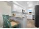 Kitchen with breakfast bar, white cabinets, and teal accents at 2294 Ocean Shore Blvd # 401, Ormond Beach, FL 32176