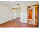 Simple bedroom with wood floors, mirrored closet, and access to hallway at 2332 Salem Dr, Deltona, FL 32738