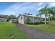 Cute Florida house with palm trees and driveway at 24514 Snail Rd, Astor, FL 32102