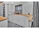 Charming galley kitchen with white cabinets and light wood countertops at 24514 Snail Rd, Astor, FL 32102