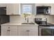 Modern kitchen with white shaker cabinets, quartz countertops, and stainless steel appliances at 311 Ora St, Daytona Beach, FL 32118