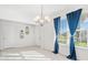 Bright dining room features a chandelier and window with blue curtains at 3404 Grassy Lake View Ave, Minneola, FL 34715