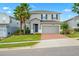 Two story house with gray siding, brick driveway, and palm trees at 3404 Grassy Lake View Ave, Minneola, FL 34715