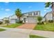Two-story house with gray siding, brick driveway, and palm trees at 3404 Grassy Lake View Ave, Minneola, FL 34715