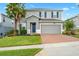 Two-story house with gray siding, brick driveway, and palm trees at 3404 Grassy Lake View Ave, Minneola, FL 34715