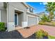 Front entry with blue door, brick walkway, and landscaping at 3404 Grassy Lake View Ave, Minneola, FL 34715