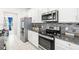 Modern kitchen with white cabinets, granite counters, and stainless steel appliances at 3404 Grassy Lake View Ave, Minneola, FL 34715