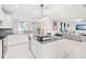 Modern kitchen with white cabinets, granite counters, and stainless steel appliances at 3404 Grassy Lake View Ave, Minneola, FL 34715