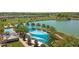 Aerial view of community pool with shade structures and a lake at 4859 Nw 35Th Lane Rd, Ocala, FL 34482