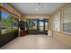 Relaxing screened porch with tiled floor, ceiling fan, and views of the backyard at 4859 Nw 35Th Lane Rd, Ocala, FL 34482