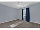 Spacious bedroom with ceiling fan and dark blue curtains at 1281 W New York Ave, Orange City, FL 32763