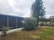 Backyard with screened porch, landscaping, and a view of the water at 1632 Bream Dr, Seville, FL 32190