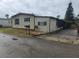 Single-wide mobile home with green trim and a screened porch at 1632 Bream Dr, Seville, FL 32190
