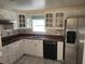White kitchen cabinets, burgundy countertops, and stainless steel appliances at 1632 Bream Dr, Seville, FL 32190