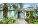 Light teal house with a welcoming entrance and tropical landscaping at 2 Walnut Ct, Ormond Beach, FL 32174