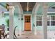 Inviting front porch with orange door and light teal exterior at 2 Walnut Ct, Ormond Beach, FL 32174