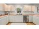 Kitchen features white cabinets, pink countertops, and stainless steel appliances at 2928 Bristol Ln, South Daytona, FL 32119